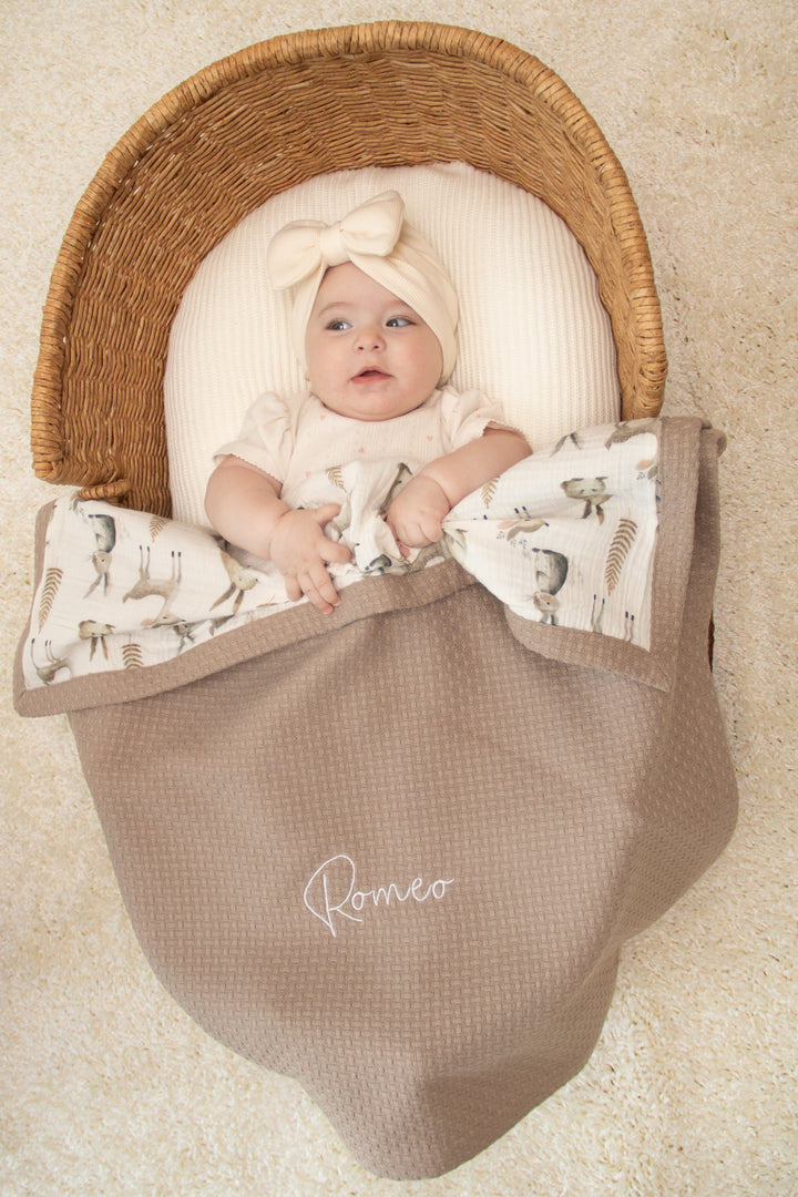 Mouliss baby in basket with personalized taupe waffle baby blanket, woodland muslin, embroidered name