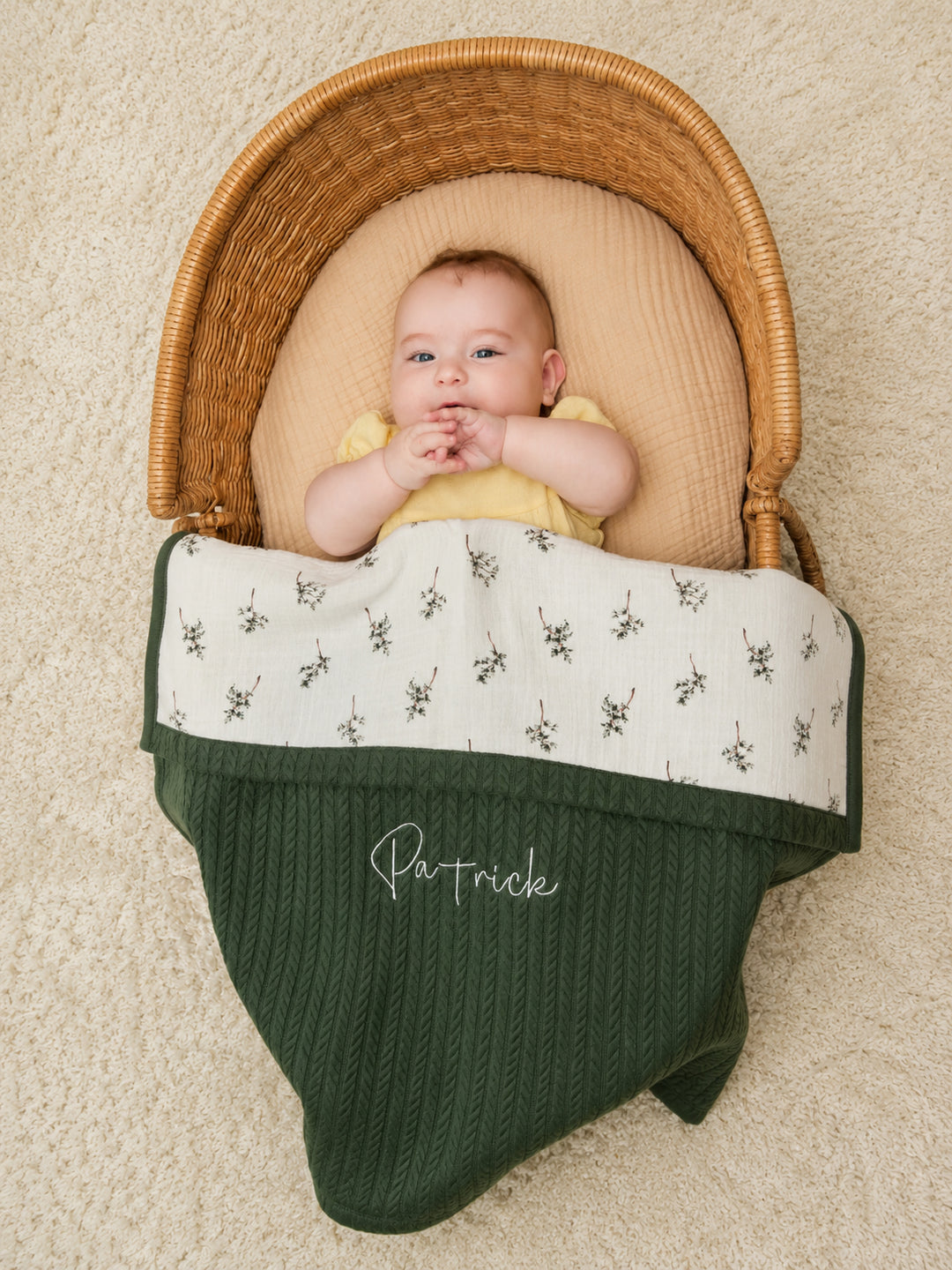 Mouliss baby in basket with personalized green cable knit baby blanket, floral muslin, embroidered name