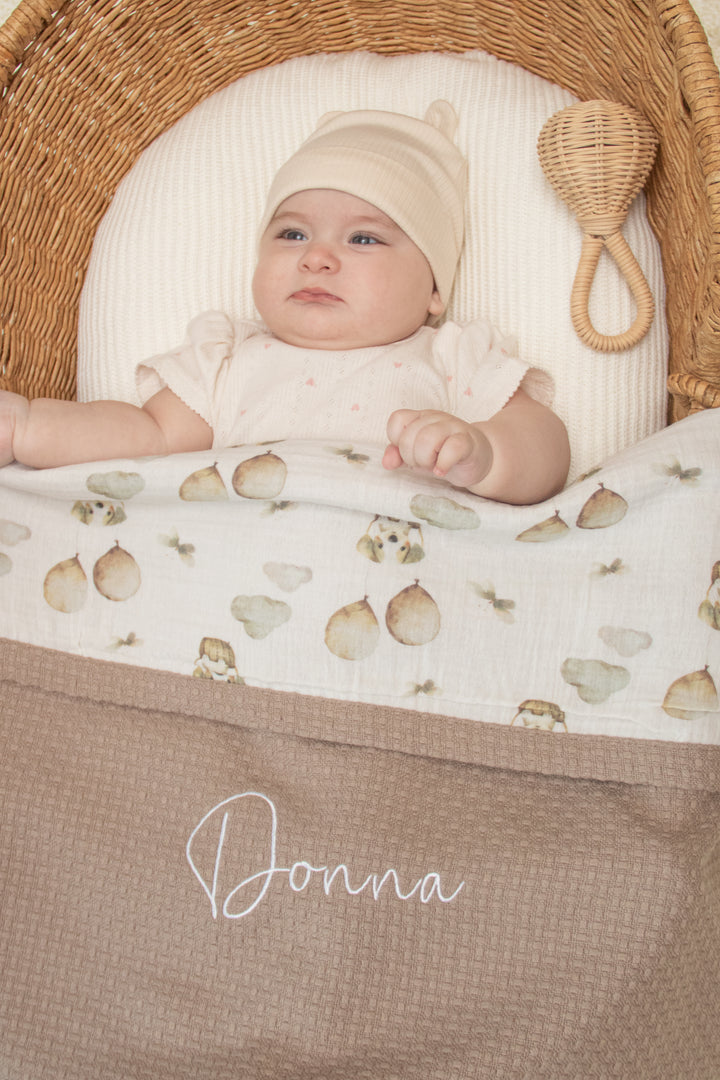 Mouliss close-up of embroidered name on personalized taupe baby blanket with woodland muslin