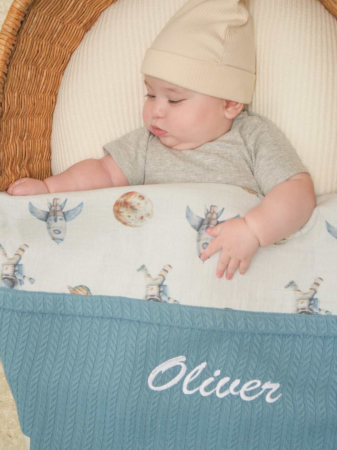 Mouliss close-up of embroidered name on personalized blue baby blanket with astronaut muslin