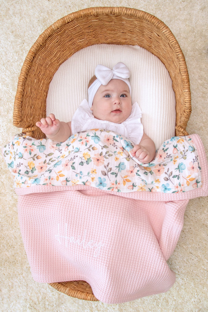 Mouliss close-up of embroidered name on personalized pink baby blanket with floral muslin