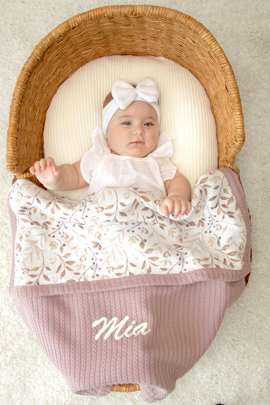 Mouliss baby in basket with personalized mauve waffle baby blanket, leaf muslin, embroidered name