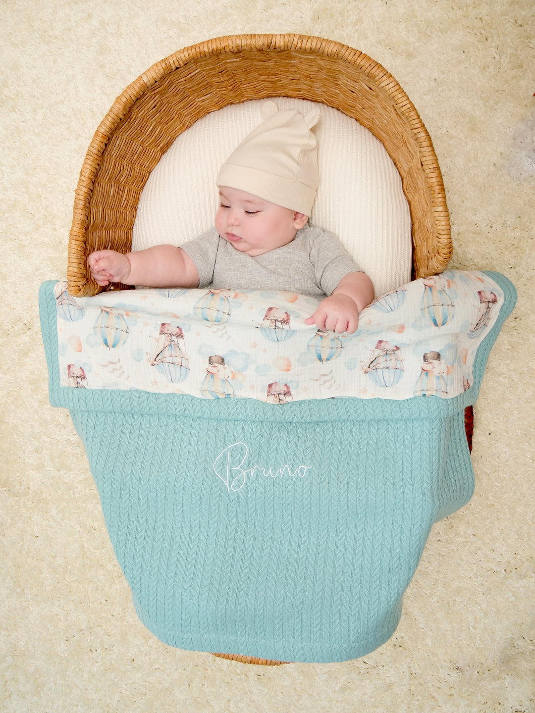 Mouliss baby in basket with personalized mint waffle baby blanket, hot air balloon muslin, embroidered name