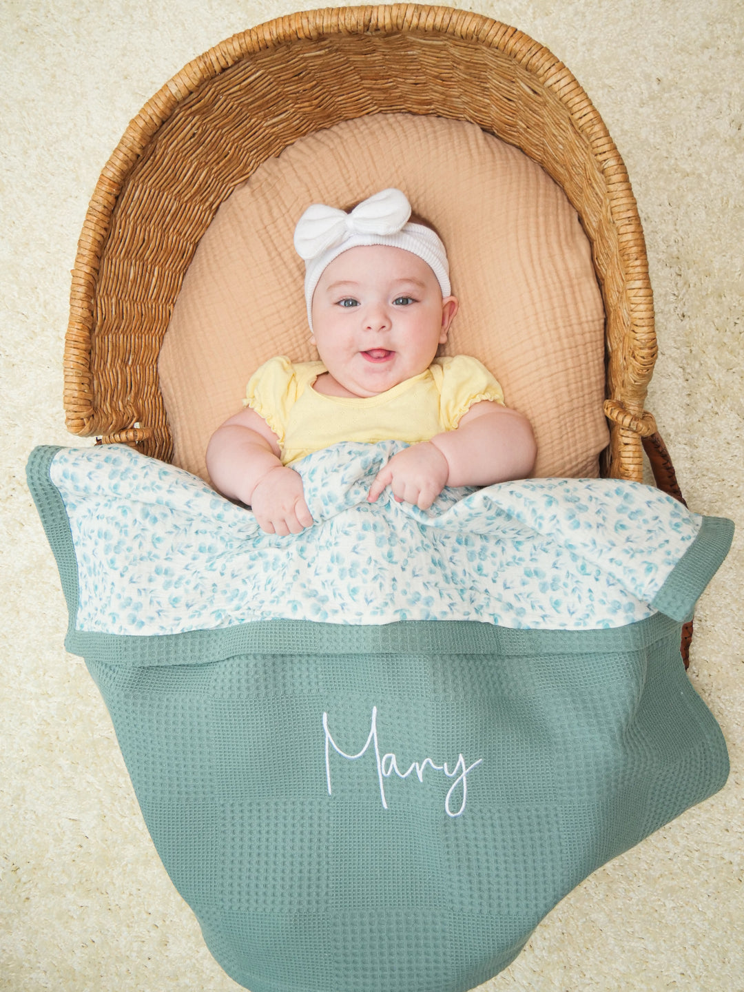 Mouliss baby in basket with personalized sage green waffle baby blanket, floral muslin, embroidered name