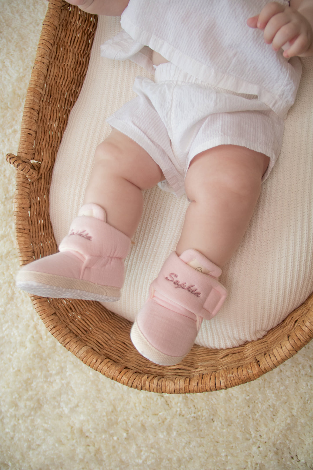 Mouliss close-up of personalized denim blue baby shoes with embroidered name in basket