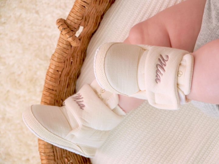 Mouliss close-up of personalized cream baby booties with custom name embroidery