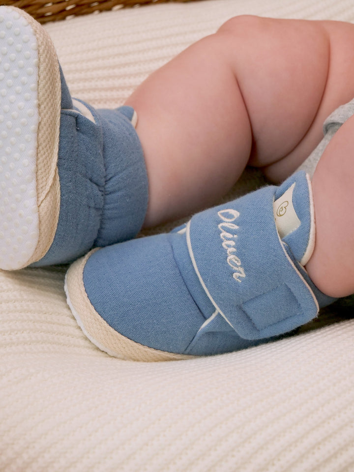 Mouliss close-up of personalized denim blue baby booties with custom name embroidery