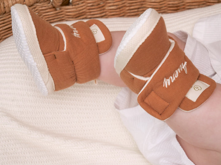 Mouliss close-up of personalized terracotta baby booties with custom name embroidery