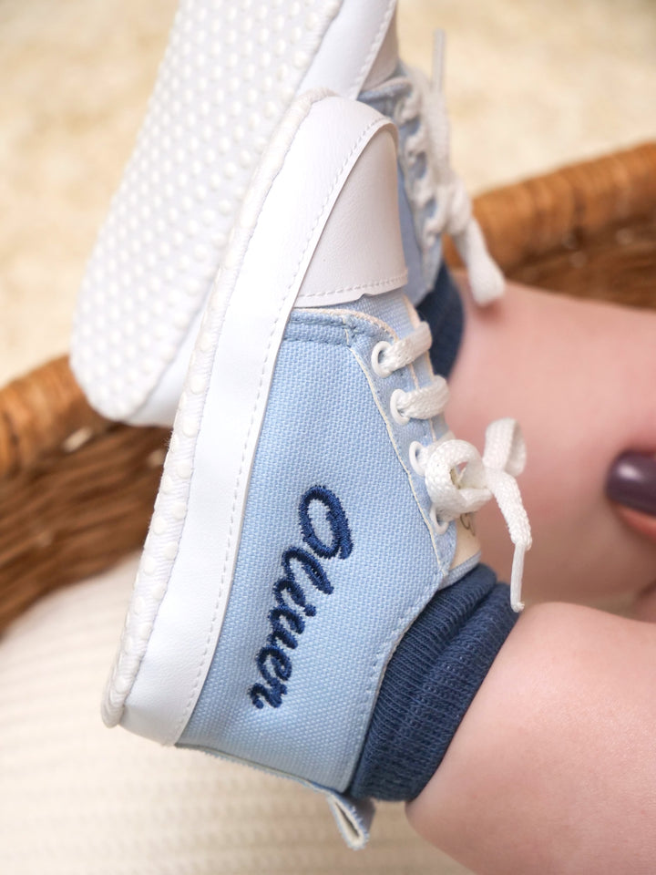 Mouliss close-up of personalized light blue canvas baby shoes with embroidered name
