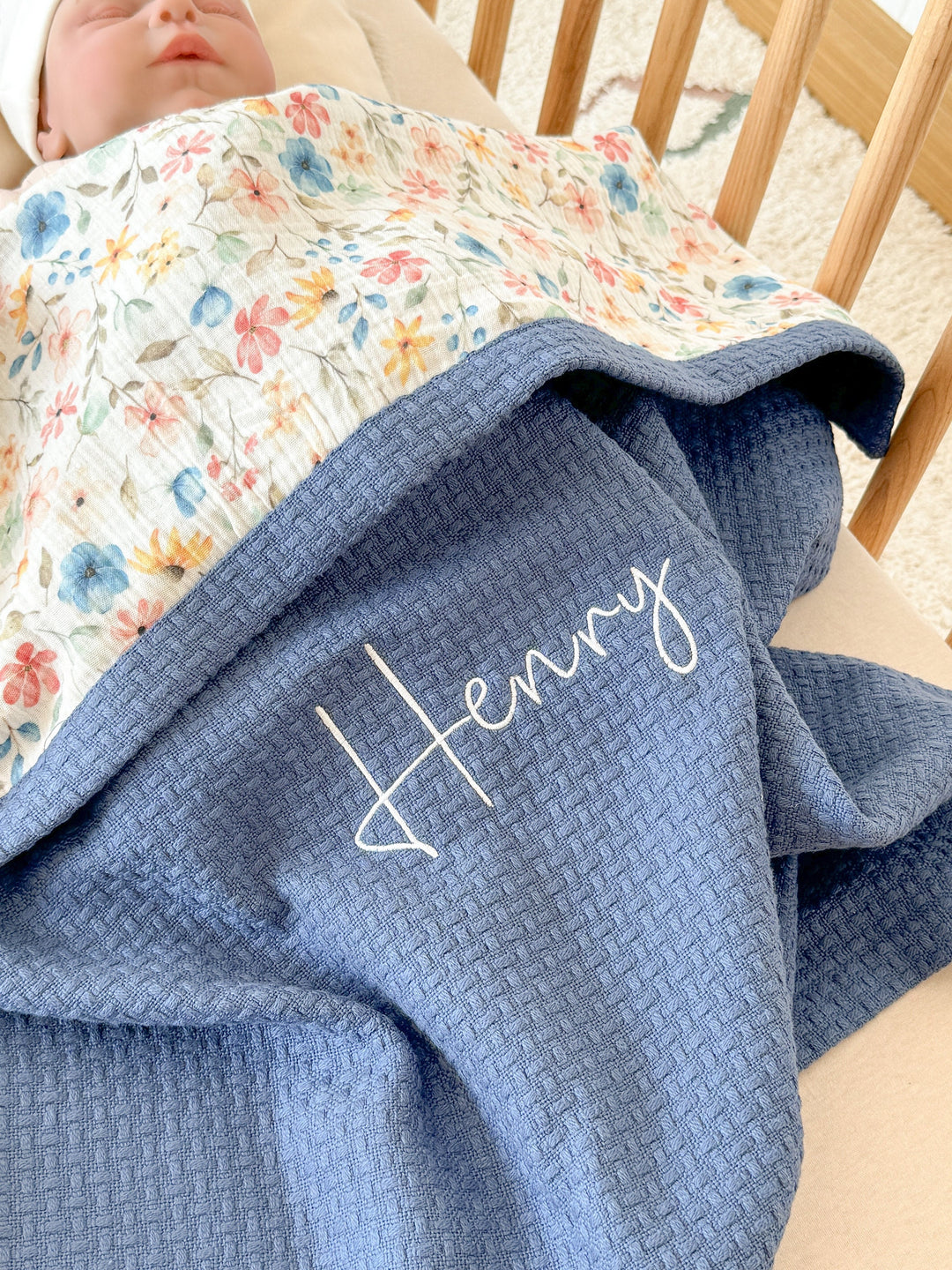 Personalized floral and blue baby blanket by Cotton, embroidered with &