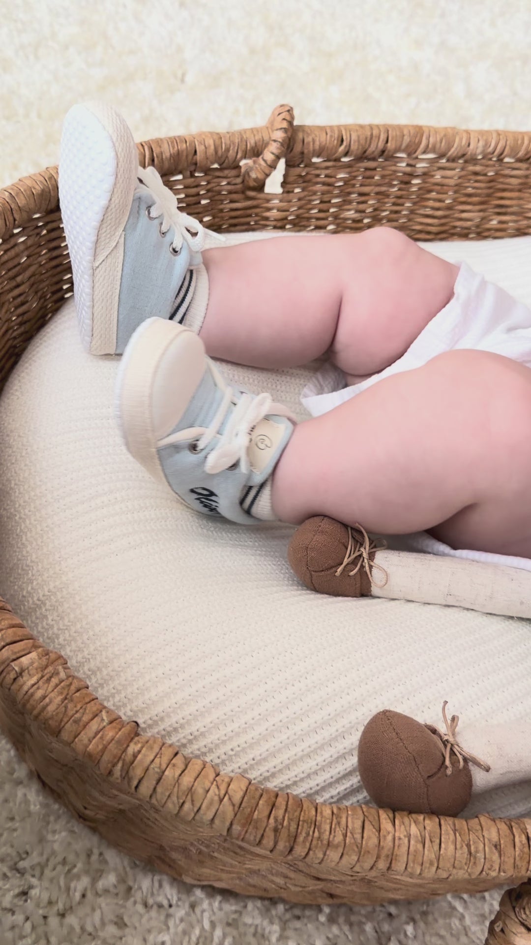 Mouliss personalized blue baby shoes with embroidered name, shown on baby in basket