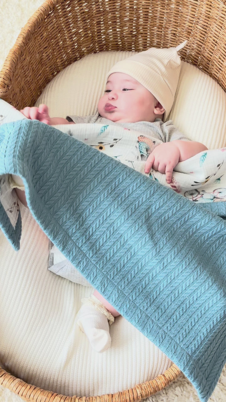Mouliss personalized blue cable knit baby blanket with bicycle muslin, embroidered name, shown in basket