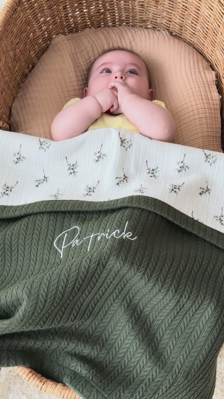 Mouliss personalized green cable knit baby blanket with floral muslin, embroidered name, shown in basket